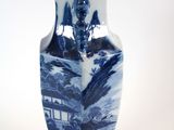 a blue and white vase sitting on a white surface