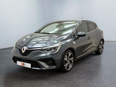 Une voiture grise est garée dans une pièce au sol noir.