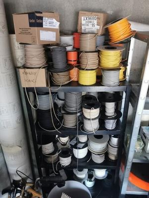 many spools of different colors and sizes on the shelves