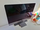 a computer monitor sitting on a desk with a keyboard and mouse