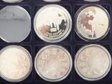 an assortment of silver and gold coins in a black box