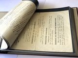 un livre ouvert posé sur une table sur laquelle se trouve un rouleau de papier
