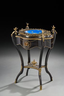 une table ancienne sur laquelle est posé un verre bleu