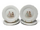 pair of porcelain plates with children on them on a white surface