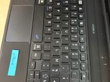 a black laptop with a blue sticker on the keyboard