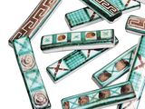 several pieces of green and brown ceramic beads with designs on them
