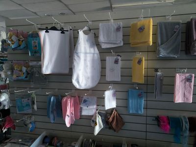many baby clothes hanging on a wall in a store