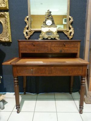 a wooden desk with a mirror and a clock on it