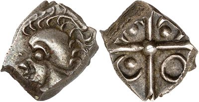 a silver coin with a cross on the front and a face on the back