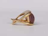 a close up of a gold ring with a purple stone on it