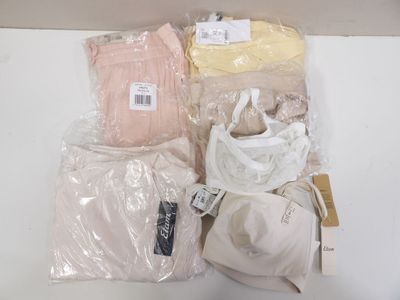 many bags of clothing and a hat sitting on a table