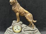 statue d'un chien assis sur un rocher, avec une horloge, sur fond noir