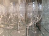 many wine glasses sitting on a glass shelf in a room