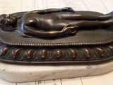 a statue of a woman laying on top of a book