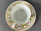 a close up of a cup and saucer on a table