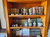 une grande bibliothèque en bois sur laquelle sont posés de nombreux livres