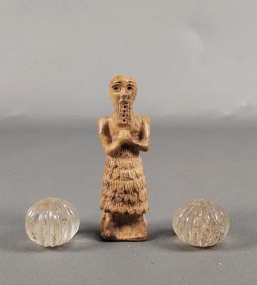 deux petites figurines représentant une femme et deux petites boules en verre