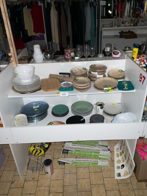une étagère blanche sur laquelle sont posés de la vaisselle et d'autres objets