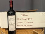 a bottle of wine sitting on top of a wooden barrel