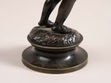 an image of a bronze statue of a boy holding a tennis racquet
