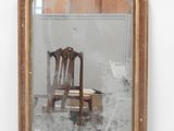 un miroir dans lequel on voit une chaise et une chaise placée devant ce miroir