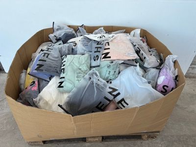 un carton rempli de vêtements posé sur une palette