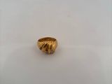 a close up of a gold ring sitting on top of a white surface