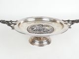 une assiette ancienne en argent sur laquelle est représenté un homme et une femme
