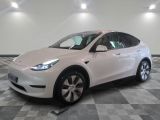 the white tesla suv is parked on a checkered tile floor