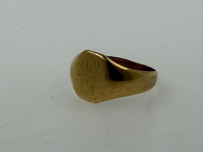 an image of a gold signet ring on a white surface