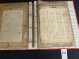 an old book opened on a table with a piece of paper in it