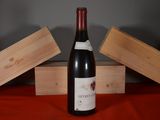 a bottle of wine sitting on a table next to two wooden boxes