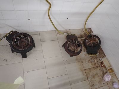 deux réchauds à gaz posés à même le sol dans la salle de bains