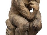 statue of a man sitting on a rock with his hand on his chin