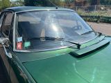 une voiture verte garée sur le bord de la route
