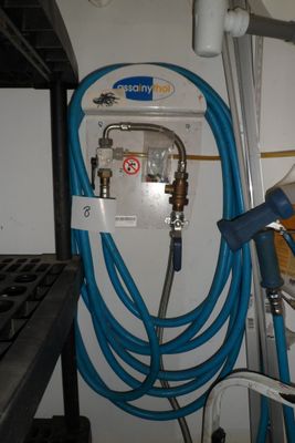 un tuyau bleu fixé au mur, à côté d'un mur blanc