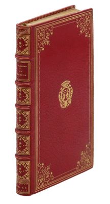 un vieux livre rouge aux tranches dorées, orné d'un emblème doré sur la couverture