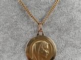 a gold coin with a woman ' s face is shown on a gold chain