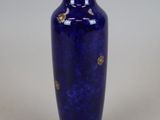 un vase bleu orné d'une décoration dorée