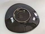 a black plate with a gold rim on a white table