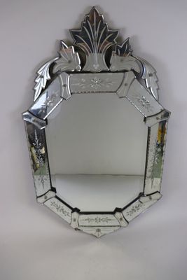 miroir à face réfléchissante, doté d'un cadre argenté et orné d'un motif décoratif
