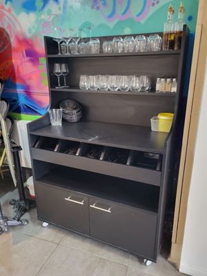 un meuble noir sur lequel sont posés des verres à vin