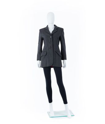 Le mannequin porte un tailleur noir et un legging noir.