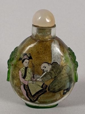 a small glass bottle with a painting on it