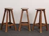 three wooden stools sitting next to each other in a room