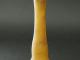 un vase jaune orné d'un motif, posé sur une table
