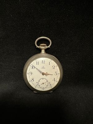 a silver pocket watch sitting on a black cloth
