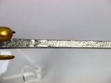 a gold bird sitting on top of a silver sword