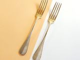 silverware on a yellow and white background with a fork and a knife