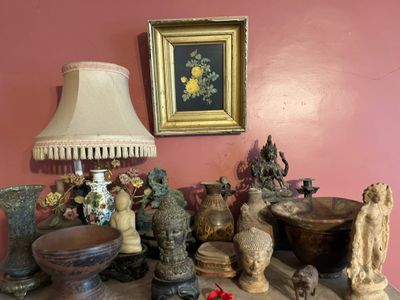 une table sur laquelle se trouvent une lampe, des vases et d'autres objets